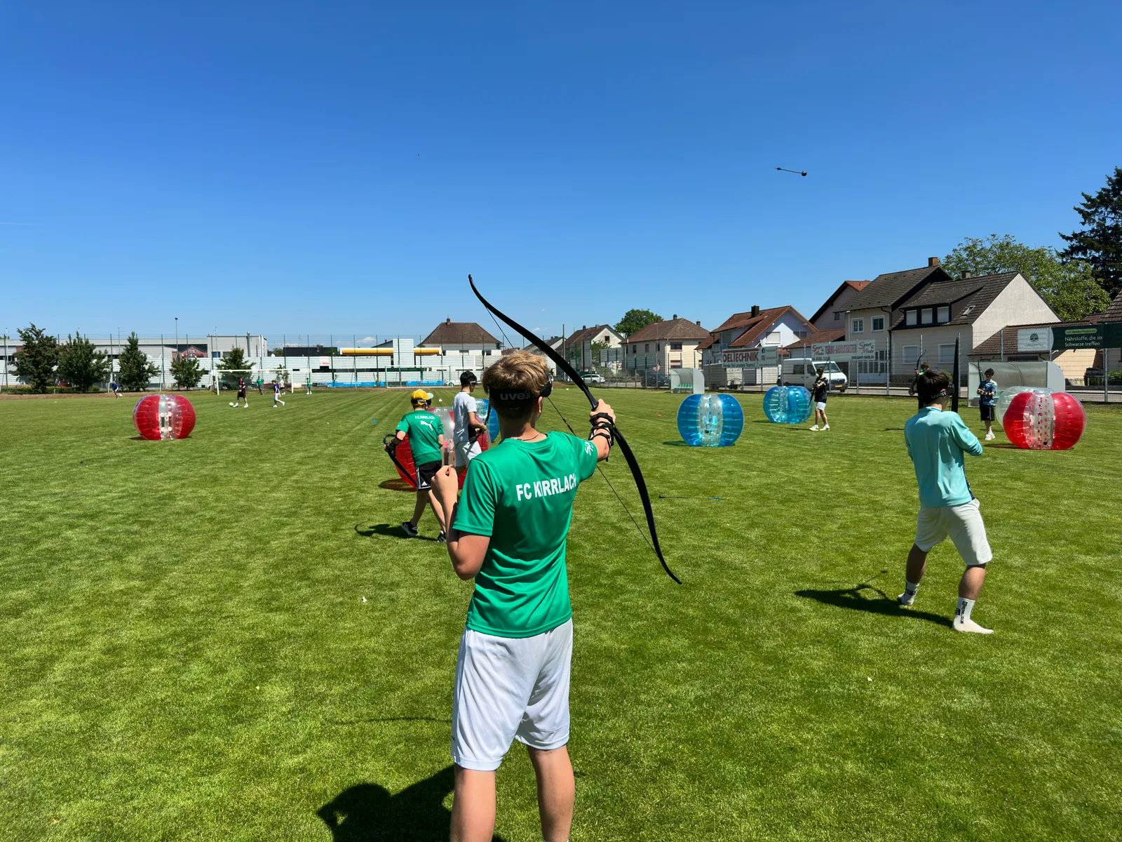 Gruppe beim Arrow Tag – Schaumstoff-Pfeil fliegt über das Spielfeld