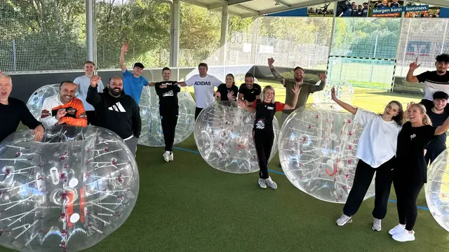 Gemischte Gruppe mit Bubbles in einer Indoor-Soccerhalle