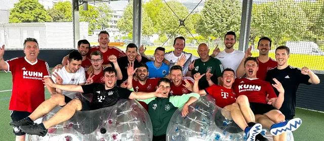 Männergruppe in Trikots jubelt nach dem Bubble Soccer