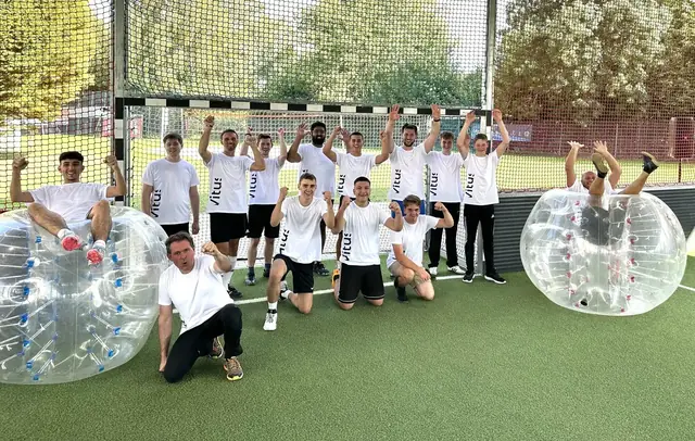Team in einheitlichen Shirts jubelt beim Bubble Soccer als Kick-off Rahmenprogramm