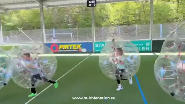 Kinder rennen in Bubbles über den Kunstrasen