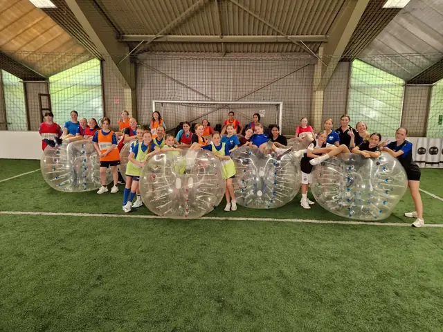 Damenmannschaft posiert mit Bubbles in der Halle