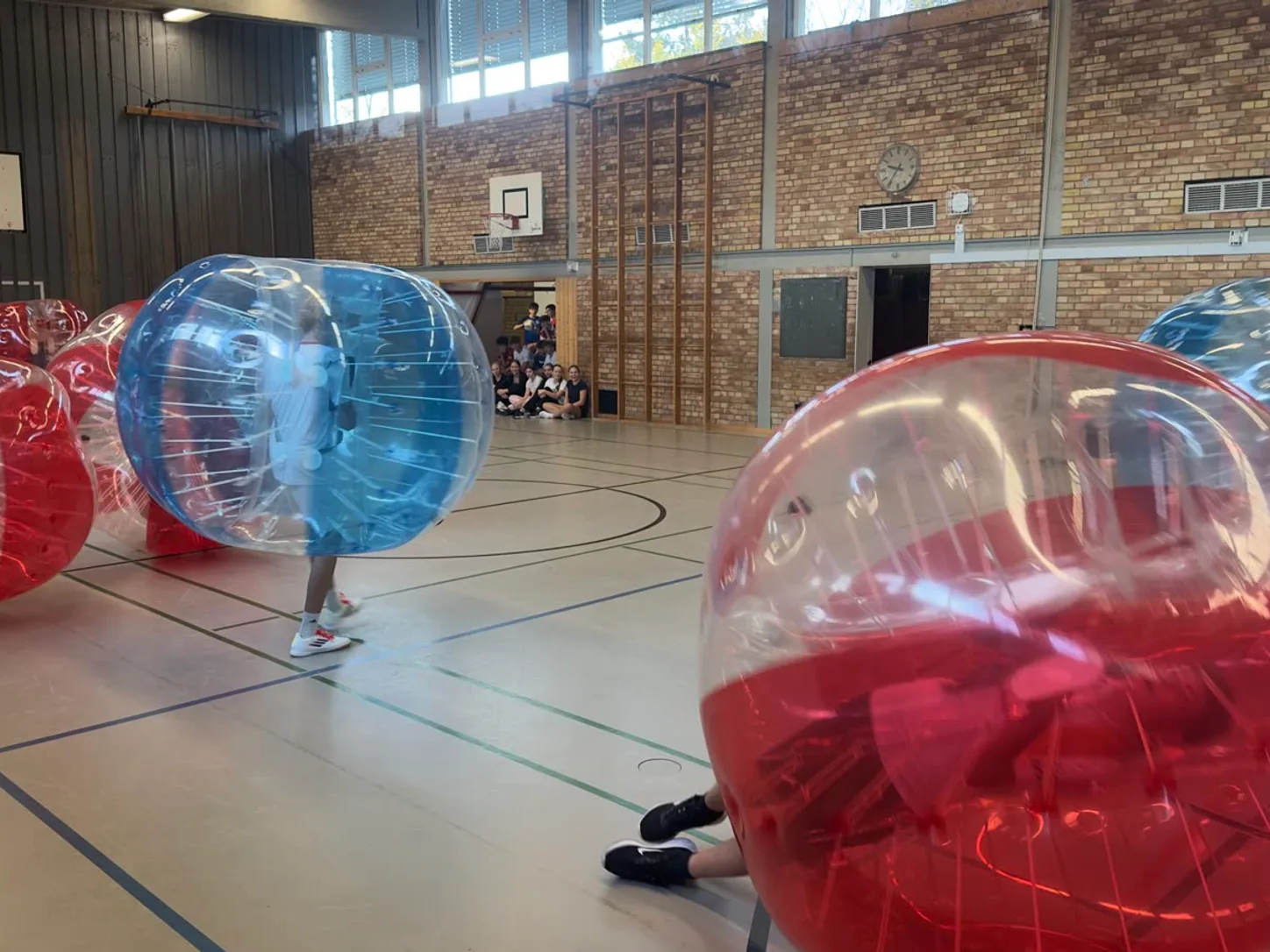 Schulklasse beim Bubble Soccer in der Turnhalle